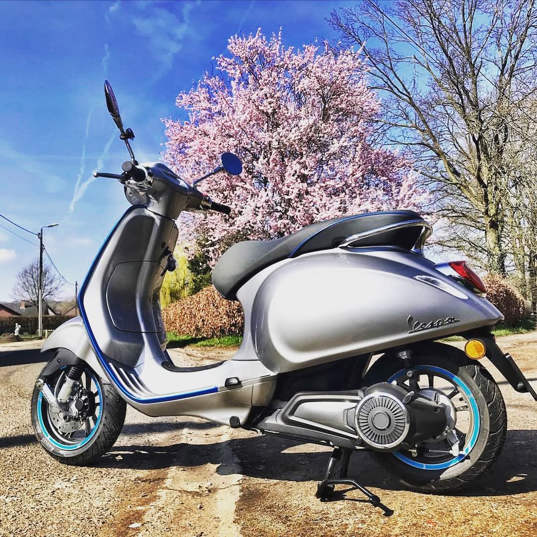 Vespa onder een bloeiende boom langs de bloesemroute